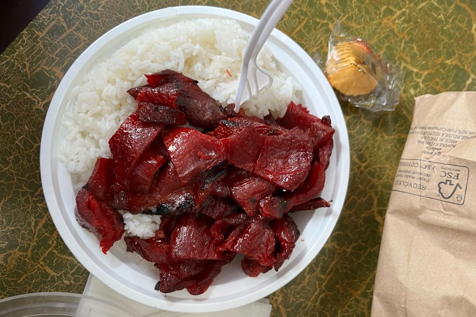 The photo shows a bowl of boneless spare ribs covered in sauce, over a bed of white rice.